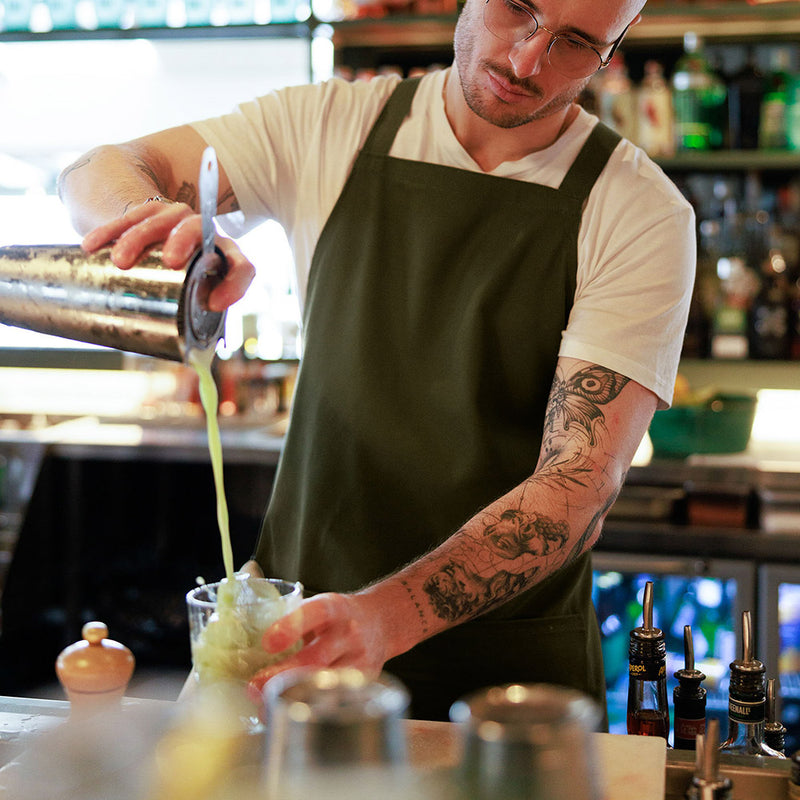 Load image into Gallery viewer, AS Colour 1082 Carrie Apron, crafted from heavy-weight 320 GSM 100% cotton canvas, features a herringbone crossover shoulder strap, metal eyelets, and a spacious front patch pocket, ideal for workwear needs.