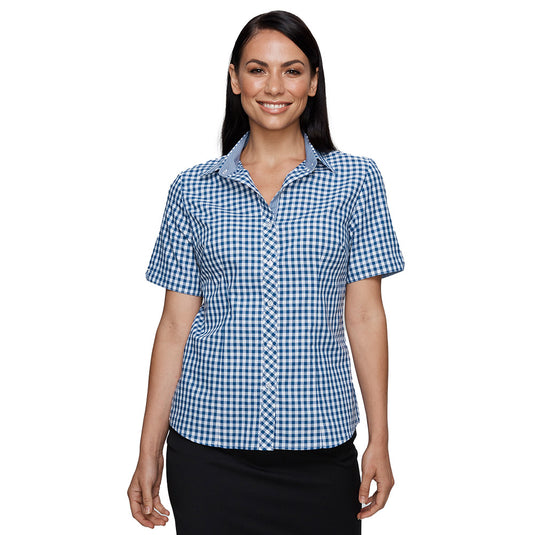 Brighton Lady Shirt Short Sleeve, worn by a smiling woman, features a blue and white checkered pattern with a subtle houndstooth inside the collar and an inverted V on the sleeve.