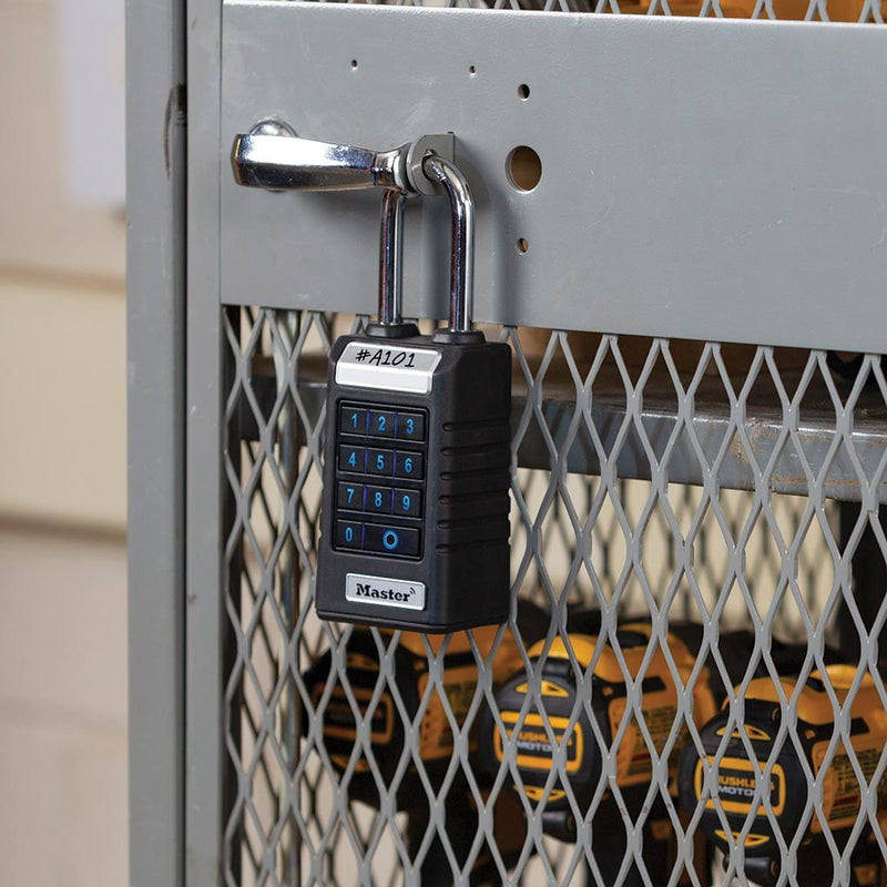 Load image into Gallery viewer, Master Lock ProSeries Bluetooth Outdoor Shackle Padlock, 60mm, secures gray metal-mesh storage cabinet door, visible through mesh: cordless drill/driver battery packs. Black key safe with numeric keypad and A101 label.