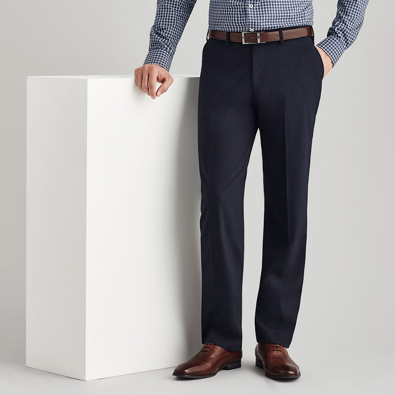 Load image into Gallery viewer, Biz Mens Comfort Wool Stretch Flat Front Pant displayed on a person leaning on a white surface, highlighting its flat front design and straight leg cut, suitable for workplace comfort and durability.
