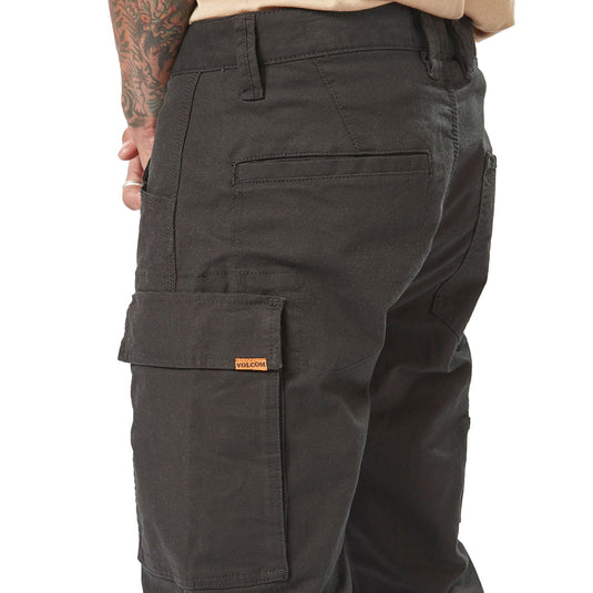Volcom Workwear Caliper Pant showcased with tattooed arm, highlighting the durable fabric and modern fit. Features include rear welt and patch pockets, dual entry cargo pocket, and reinforced stitching for enhanced durability.