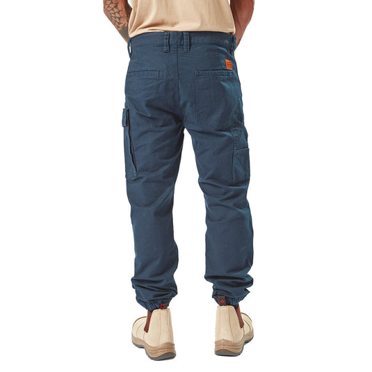 Volcom Workwear Caliper Cuffed Pant worn by a person, featuring modern Solver fit, dual cargo pockets, reinforced knees, and comfort elastic cuffs, exemplifying durability and style for active use.