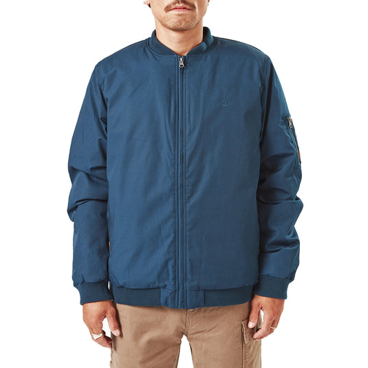 Volcom Workwear Water Resistant Bomber Jacket, featuring a waist-length design with a brushed tricot lining, zipper sleeve pocket, and heavy-weight polyester insulation, modeled by a man with a mustache.