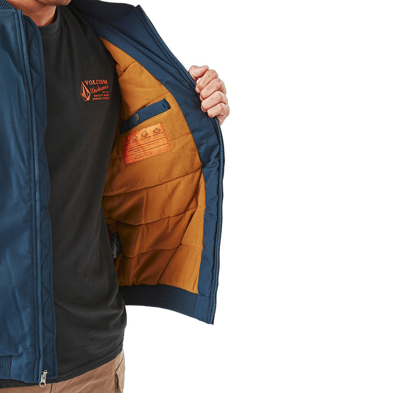 Load image into Gallery viewer, Volcom Workwear Water Resistant Bomber Jacket held by a man, showcasing its waist-length design, zipper sleeve pocket, and durable finish, embodying the brand's commitment to style and functionality for active environments.