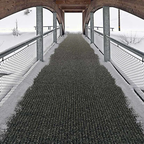 AKO Non Slip Safety Mat: 1800 x 10m Roll on a snowy walkway, showcasing its slip-resistant surface ideal for winter conditions. Perfect for ensuring safety on outdoor paths and ramps.