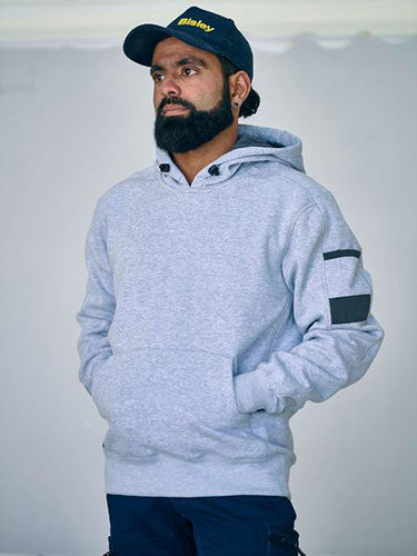 Load image into Gallery viewer, Man wearing Bisley Work Fleece Pullover Hoodie, featuring a shaped hood with contrast lining, adjustable toggle, front kangaroo pouch pocket, and sleeve pocket. Ideal for safety and workwear needs.