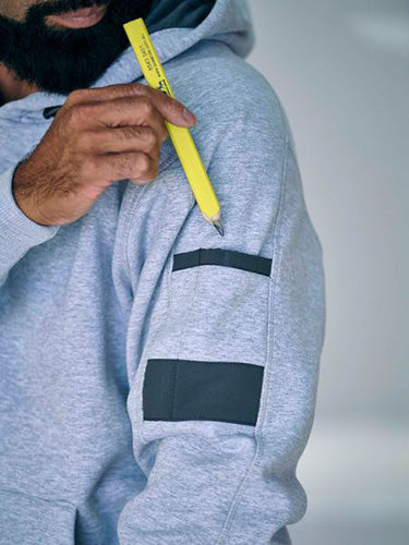 Load image into Gallery viewer, Bisley Work Fleece Pullover Hoodie shown with a man holding a pencil in the sleeve pocket's pen division. Features include a shaped hood, front kangaroo pouch, and reinforced panels, ideal for workplace use.
