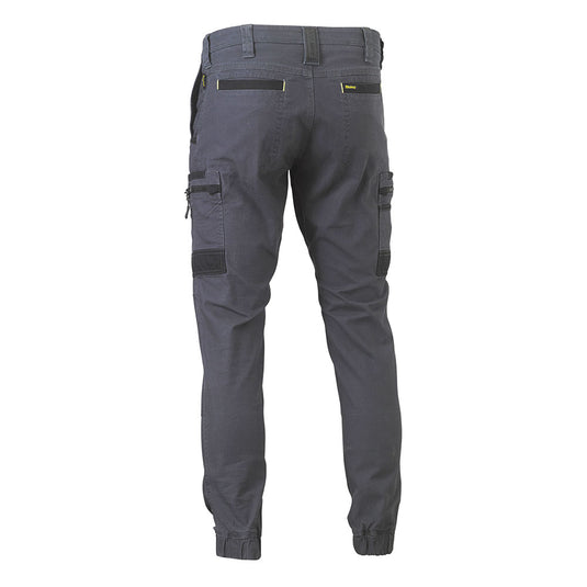 Bisley Flex & Move Stretch Cargo Cuffed Pants showcase a back view, featuring elasticized ankle cuffs, two back welt pockets, and multifunctional cargo pockets on each thigh, reflecting a durable, modern workwear design.