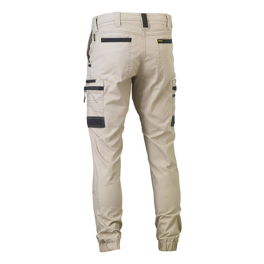 Bisley Flex & Move Stretch Cargo Cuffed Pants, featuring slim-fit design, back yoke, contrasting-trim pockets, zippered and patch side cargo pockets, tapered elasticated cuffs, reinforced belt loops, and double-layer knees for durability.