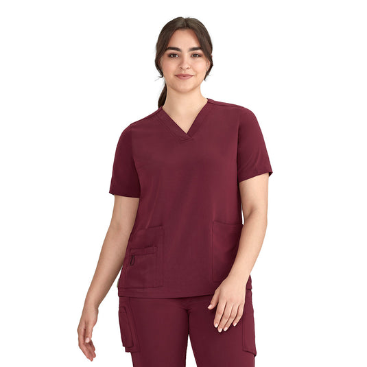 Bizcare Womens Avery V Neck Scrub Top, designed for durability and comfort, features functional side splits, five pockets, and utility loops. Ideal for demanding environments with a modern fit and modest neckline.