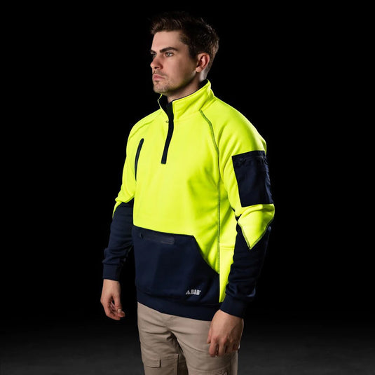 BAD Waterproof Rain-Defend Hi-Vis Fleece 1/4 Zip Jumper, worn by a man, features a front pouch with a waterproof pocket, multiple utility pockets, and elasticated wrists and waist for warmth.