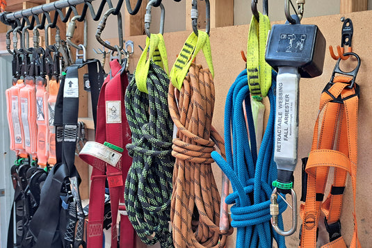 Height Safety equipment hanging up on a wall ready for hire from one of Active Safety's retail stores. There are height safety lanyards, ropes, harnesses and fall arrest equipment available to hire.