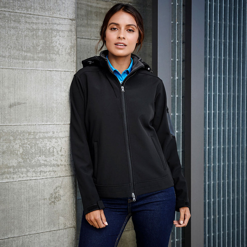 Load image into Gallery viewer, Close-up of a woman wearing the Biz Ladies Summit Jacket, showcasing its detachable hood and adjustable cuffs, emphasizing water repellent, breathable, and windproof features designed for active safety.