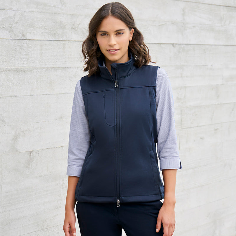 Load image into Gallery viewer, Biz Ladies Soft Shell Vest worn by a woman, featuring a stand-up collar, zippered chest pocket, and concealed front pockets. Ideal for safety and workwear, reflecting Active Safety's commitment to quality.