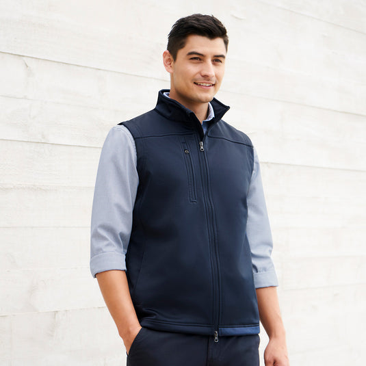 Biz Mens Soft Shell Vest worn by a man, featuring a stand-up collar, two-way front zip, and zippered pockets, ideal for safety and workwear environments.
