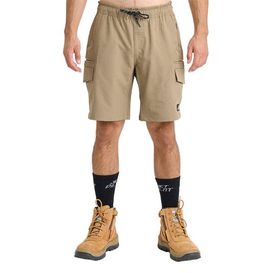 Model wearing Jetpilot Jet-Lite Hybrid 20 Utility Short, showcasing knee-length khaki cargo shorts with elastic waistband, flap thigh pockets, and rugged tan work boots, ideal for active, safety-focused work environments.