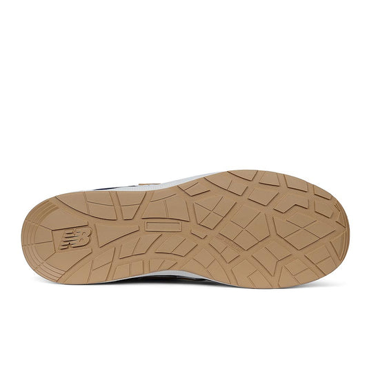 Underside of New Balance Elite Lite Safety Shoe, Blue/Coffee, showing gum-rubber tread with NB logo, highlighting slip-resistant outsole designed for workplace safety and comfort.