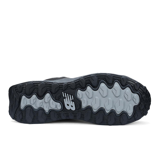 New Balance Fresh Foam Cremorne Mid 2E Safety Boot showcases a black outsole with patterned rubber tread and light gray traction pods, featuring the NB logo, emphasizing slip resistance and robust performance.