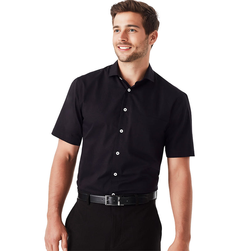 Load image into Gallery viewer, Biz Charlie Classic Fit S/S Shirt featuring a close-up of a man wearing a black dress shirt with white buttons, highlighting the shirt's smart casual design suitable for work environments.