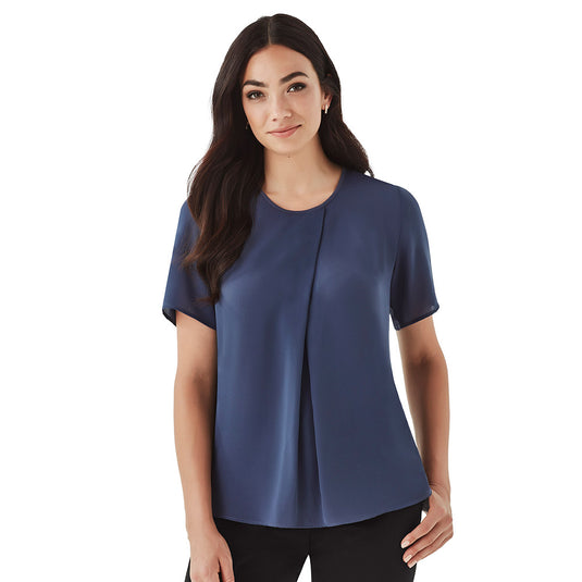 Biz Sydney Womens Short Sleeve T-Top features a loose fit with a Georgette front and sleeves, visible as a woman models it with black pants, showcasing its elegant, breezy design.