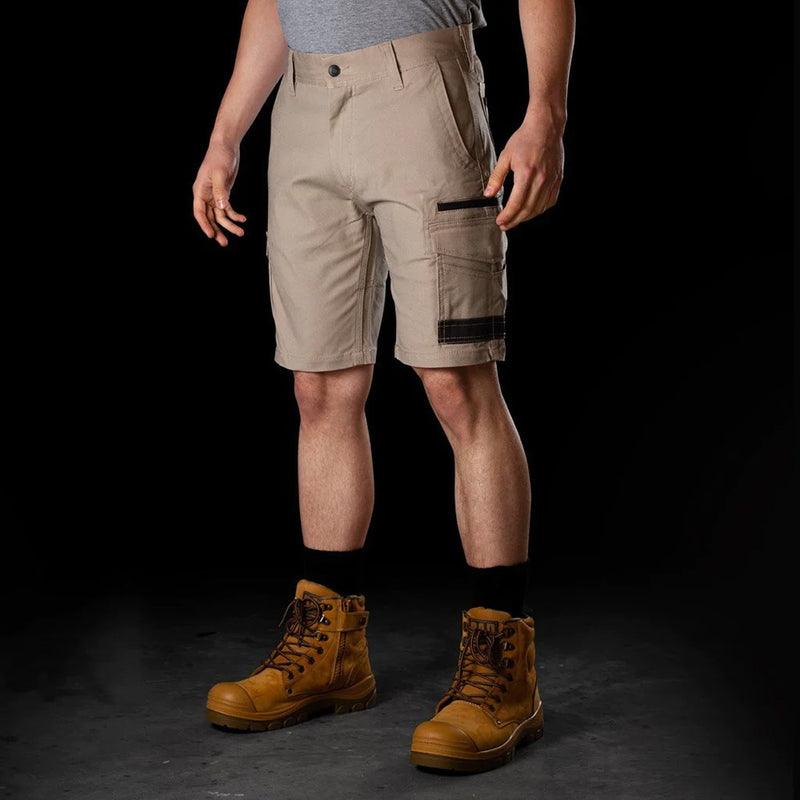 Load image into Gallery viewer, BAD Attitude Slim Fit Work Shorts, featuring a man wearing them with brown boots, highlighting reinforced pockets and a smartphone pocket; ideal for active, safety-focused work environments.