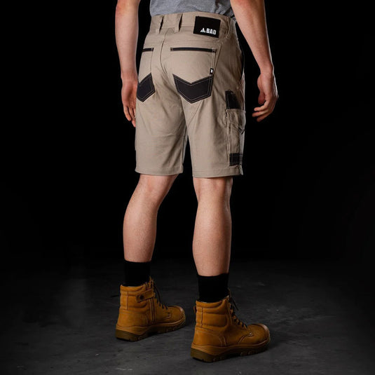 BAD Attitude Slim Fit Work Shorts featuring reinforced pockets, a ruler/tool pocket, a secure smartphone pocket, and a hammer loop, worn with brown boots, embodying durable workwear for active safety environments.