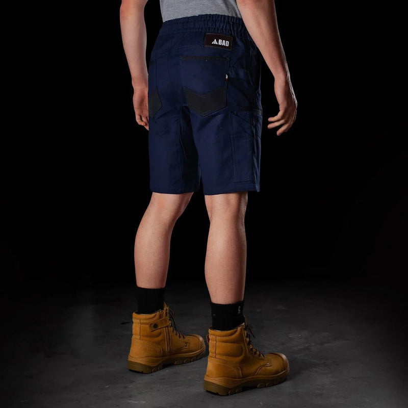 Load image into Gallery viewer, BAD Saviour Elastic Waist Work Shorts displayed, showcasing the adjustable drawstring and reinforced pockets. Paired with brown boots, highlighting the shorts’ 4.5-inch inseam and breathable, stretchy fabric. Ideal for active work environments.