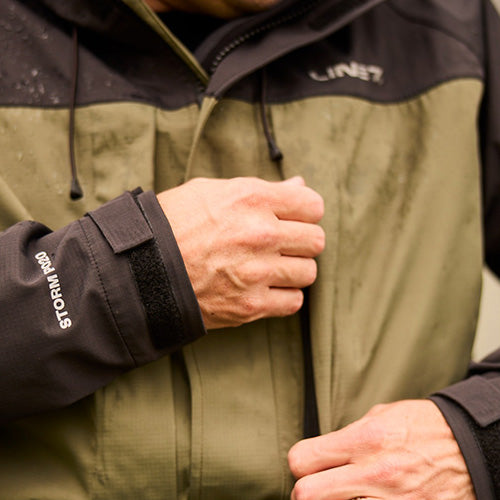 Load image into Gallery viewer, Line 7 Territory Storm Pro20 Waterproof Jacket worn by a person, showcasing its durable design with adjustable hood and multiple waterproof pockets, ideal for high-level protection in demanding environments.