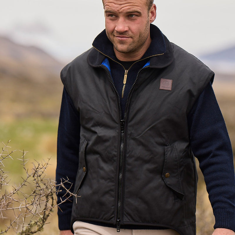 Load image into Gallery viewer, Swanndri Foxton Wool Lined Vest, featuring a waxed cotton outer and wool-lined interior, designed for outdoor activities, with secure zip-side pockets and a durable two-way zip for functionality and comfort.