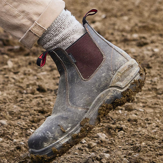 A John Bull Slip On Safety Boot with mud stuck to the sole of the boot. These Safety Boots look to be quite durable and work well in muddy and dirty conditions.