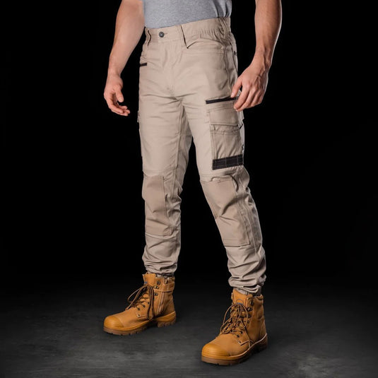 BAD Attitude Slim Fit Cuffed Work Pants with brown boots, showcasing reinforced knees, comfort elastic sides, and cuffed ankles, emphasizing durability and functionality for active work environments.