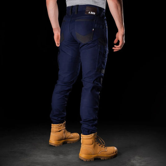 BAD Attitude Slim Fit Cuffed Work Pants featuring reinforced knees, triple stitching, and multiple utility pockets, worn by a man with brown boots, highlighting the pants' fit and functionality.