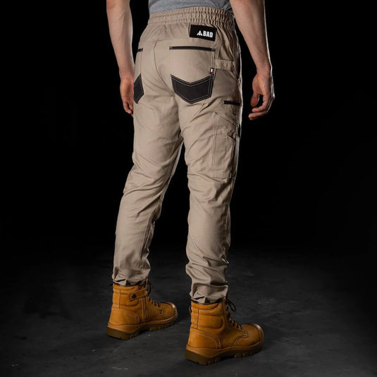 BAD Saviour Cuffed Elastic Waist Work Pants showcased with brown boots, highlighting reinforced pockets and adjustable drawstring. Ideal for active safety environments, featuring durable construction and practical utility pockets.
