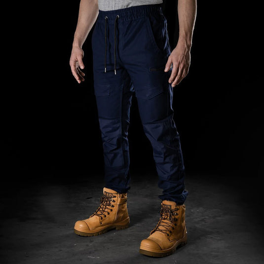 BAD Saviour Cuffed Elastic Waist Work Pants showcased with brown boots, featuring a slim fit, reinforced pockets, and utility pockets. Ideal for safety-conscious work environments, highlighting comfort and practicality.