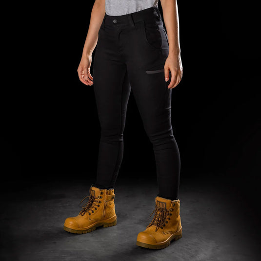 BAD Womens Flex Hypermove Work Jeggings are showcased, featuring a mid-high waist and reinforced pockets. Paired with yellow boots, these jeggings highlight their 360-degree stretch and utility-focused design.