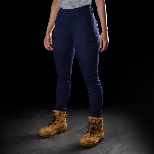BAD Womens Flex Hypermove Work Jeggings showcased, featuring a person wearing blue jeggings and brown boots. Highlighting all-day comfort and utility with reinforced pockets and triple stitching. Ideal for active work environments.