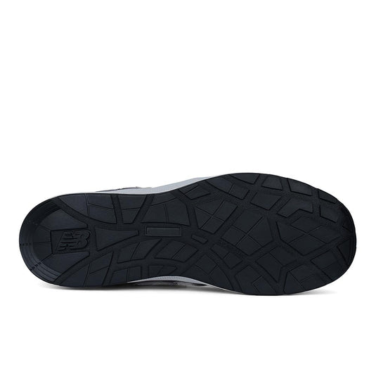 Underside view of the New Balance Elite Lite Womens Safety Shoe, featuring a black tread-patterned outsole with the NB logo, designed for slip resistance and safety in light industrial settings.