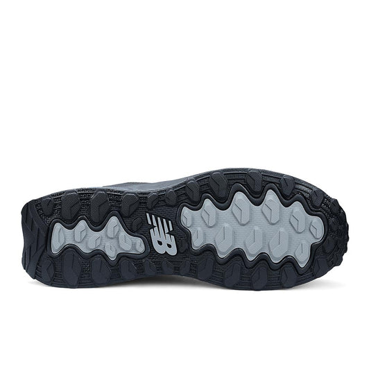 Underside of New Balance Fresh Foam Cremorne Women's Safety Shoe, Black/Grey, showcasing lugged tread pattern in dark and light gray rubber with NB logo, highlighting slip resistance and durability for workplace safety.