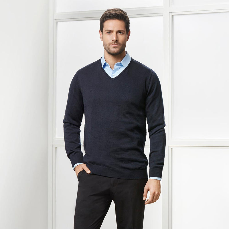 Load image into Gallery viewer, Biz Mens Milano Pullover showcased on a seated man, highlighting its contemporary V-neck style and ribbed side panel detail, ideal for layering over collared shirts.