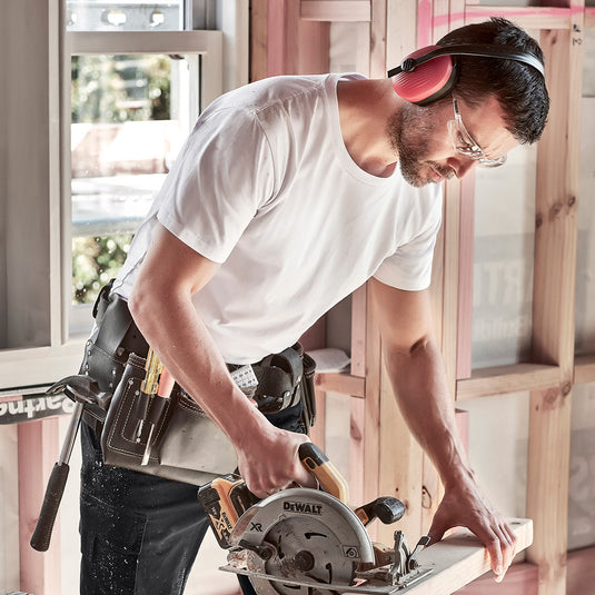 Syzmik Streetworx T-Shirt worn by a man using a circular saw, featuring a slim fit and longer tail with a curved hem, highlighting its durable design suitable for safety-focused environments.