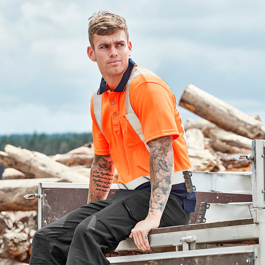Syzmik Hi Vis Taped Short Sleeve Polo featuring reflective tape, chest pocket with pen insert, and crafted from 100% polyester. Designed for moisture-wicking, breathability, and quick drying, ideal for workplace safety.