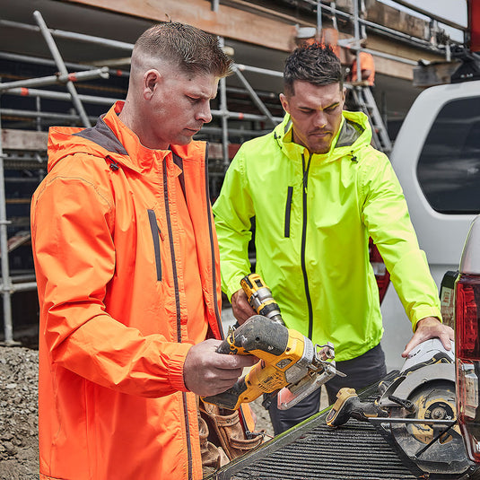 Syzmik Unisex Super Light Packable Rain Jacket, showcasing its lightweight design with secure zippered pockets, adjustable storm cuffs, and a peaked hood, ideal for wet weather protection and workplace safety.