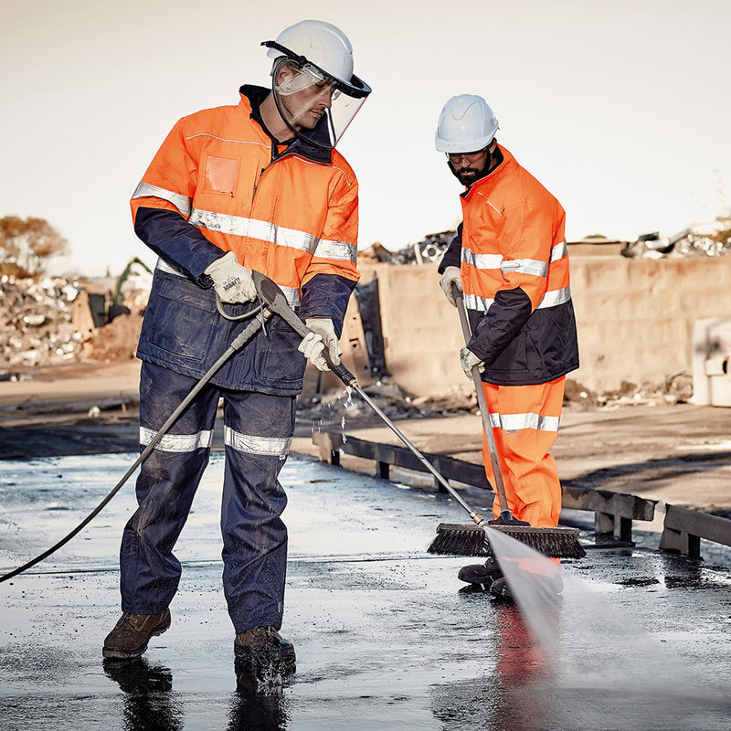 Load image into Gallery viewer, Syzmik Hi Vis Storm Rain Jacket worn by construction workers, showcasing its waterproof design, reflective tape, and practical pockets, ideal for safety and efficiency in outdoor work environments.