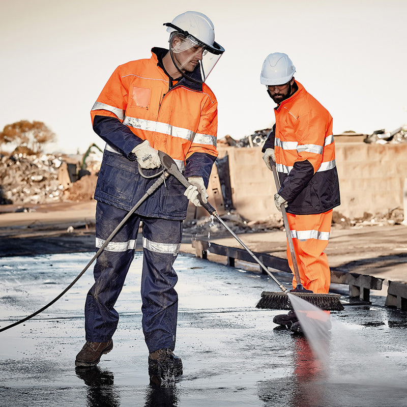 Load image into Gallery viewer, Syzmik Taped Storm Trouser, worn by men with helmets, features reflective tape and elasticated waist, showcasing its waterproof, seam-sealed design ideal for safety and workwear environments.