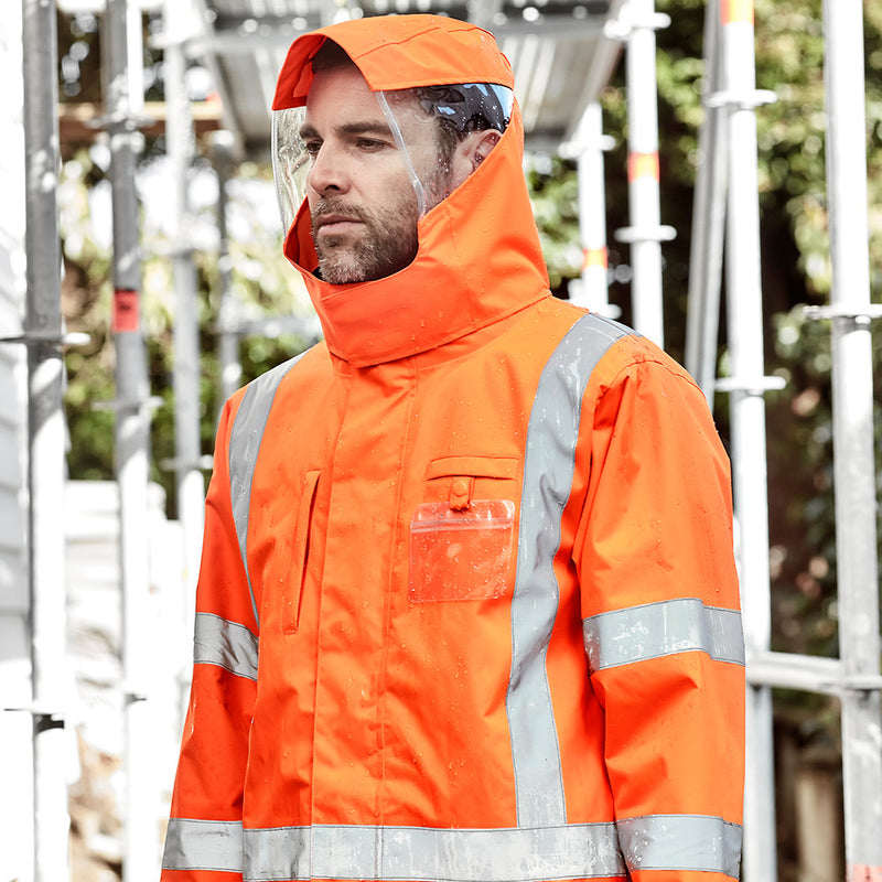 Load image into Gallery viewer, Syzmik TTMC-W23 X-Back 4-in-1 Combo features a man in a waterproof orange raincoat with a reversible fleece-lined vest, highlighting its high-visibility and protective workwear design suitable for safety-focused environments.