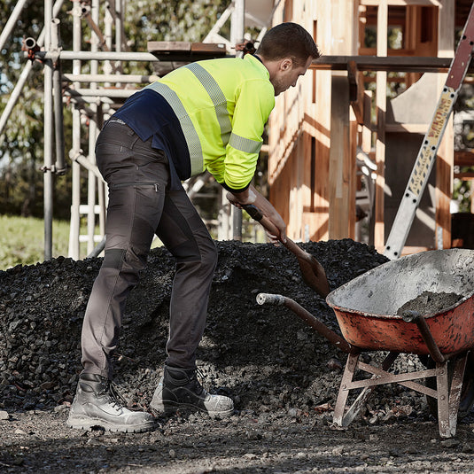 Syzmik Streetworx Stretch Pant (Non-Cuffed) showcased on a construction worker, highlighting modern slim fit, stretch panel for ease of movement, and multiple functional pockets, ideal for active work environments.