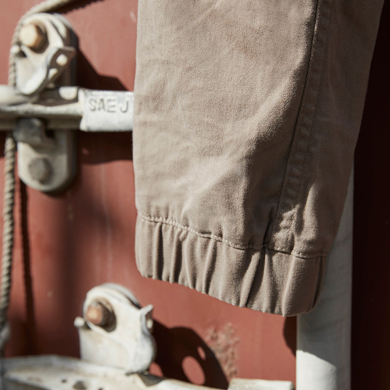 Load image into Gallery viewer, Syzmik Streetworx Stretch Pant, featuring a modern slim fit with elastic cuff hem, visible large pockets with black zips, and stretch pleating for enhanced movement, ideal for active work environments.