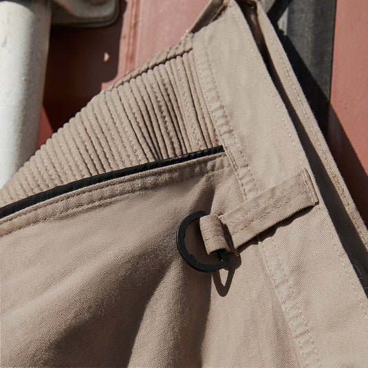 Syzmik Streetworx Stretch Pant showcasing a close-up of a pocket with black bonded zips and a metal ring, emphasizing the pant’s functional design and modern slim fit for workplace safety.