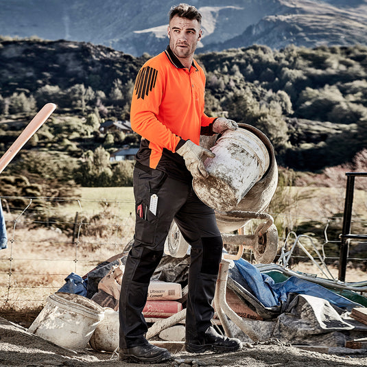 Syzmik Streetworx Tough Pant shown in outdoor work setting, highlighting durable knee reinforcement, multiple pockets, and a comfortable fit, ideal for active safety and work environments.