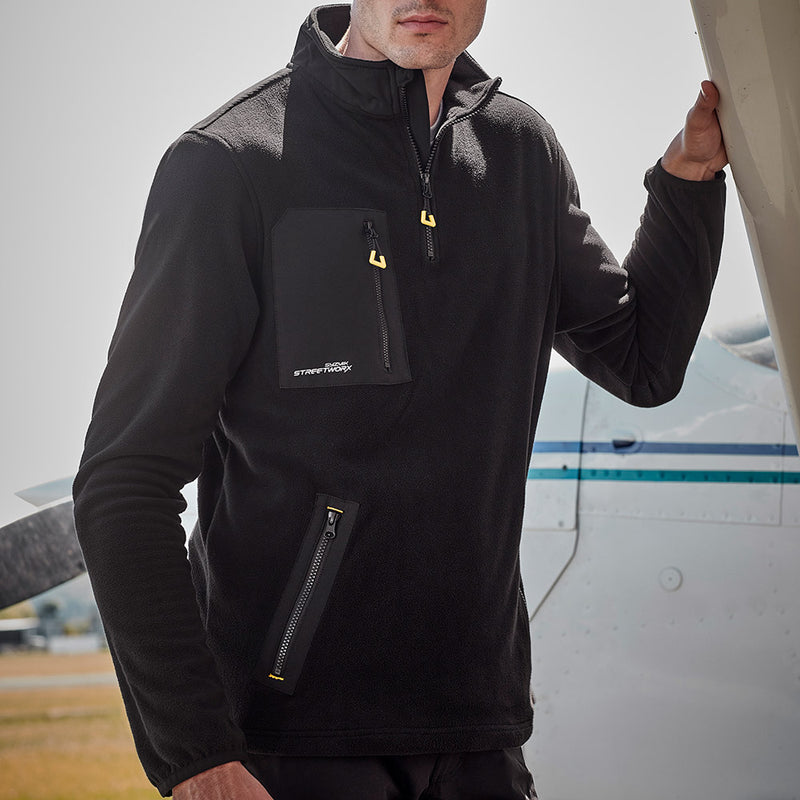 Load image into Gallery viewer, Syzmik Streetworx Lightweight 1/4 Zip Polar Fleece featuring a durable upper back panel, reflective branding, and multiple zippered pockets for enhanced functionality, ideal for safety-focused work environments.